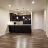Open apartment interior with kitchen and wood-look floors
