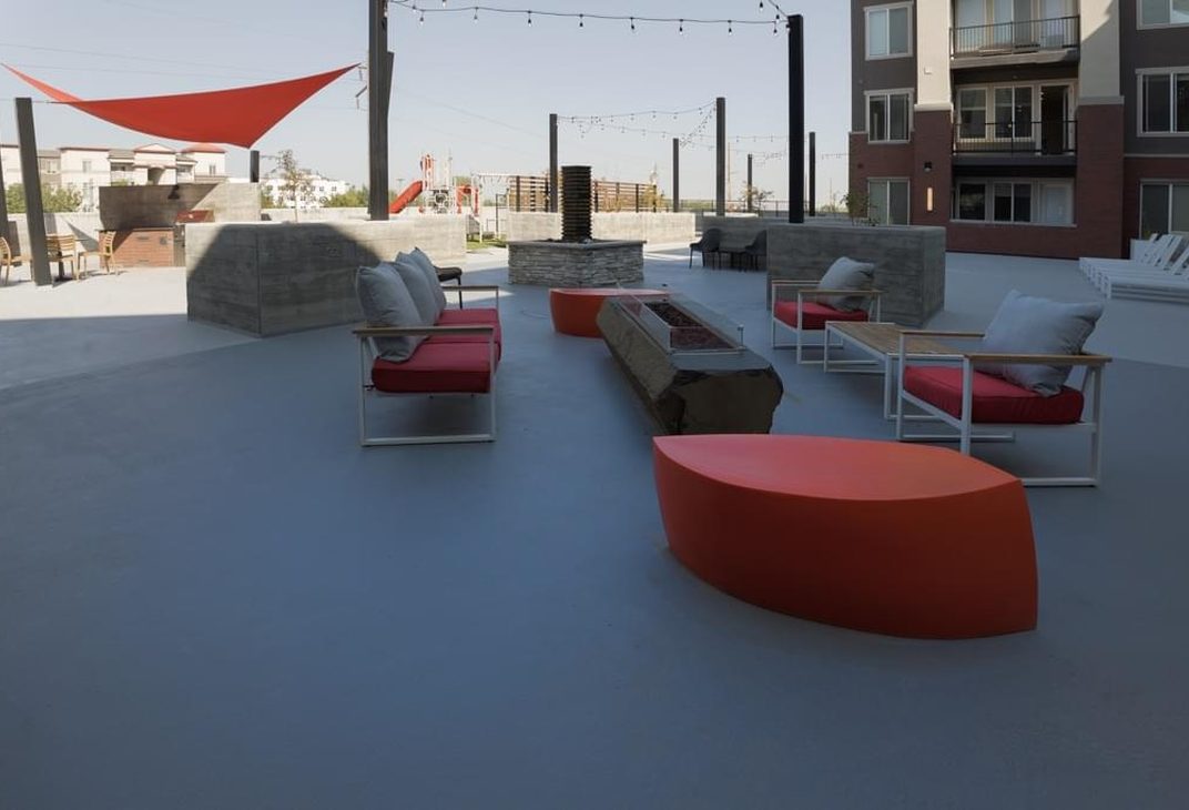 Outdoor lounge with red seating and shade sails