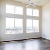 Bright living room with tall windows and ceiling fan